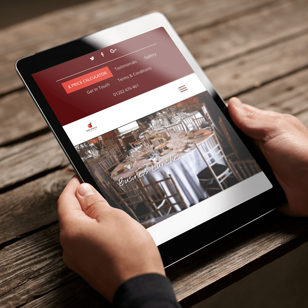 person looking at Red cherry catering website on an iPad